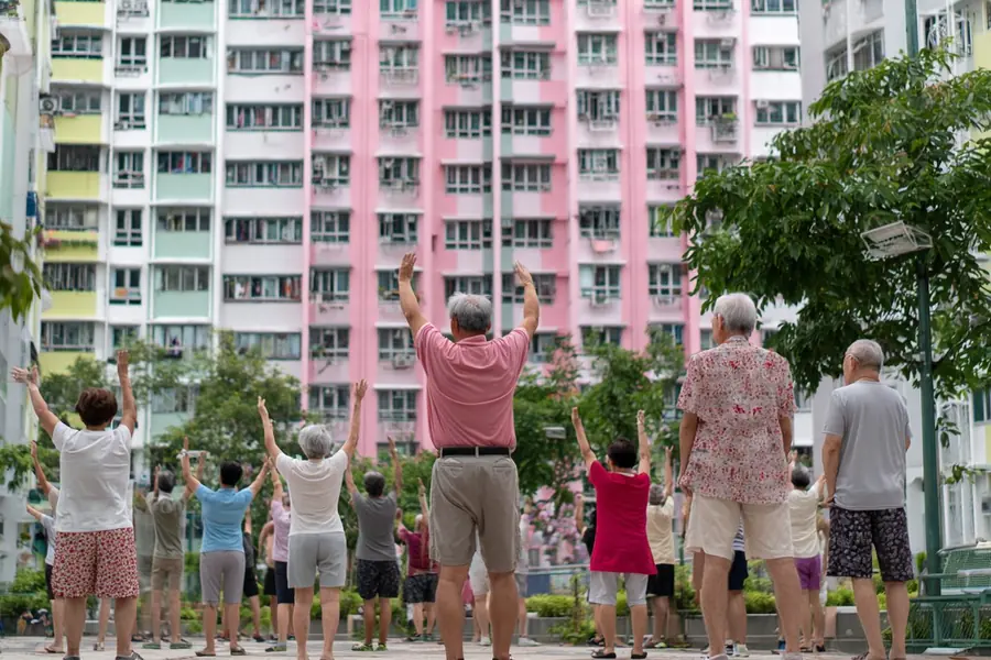 A group of residents exercising together outside their block in the morning