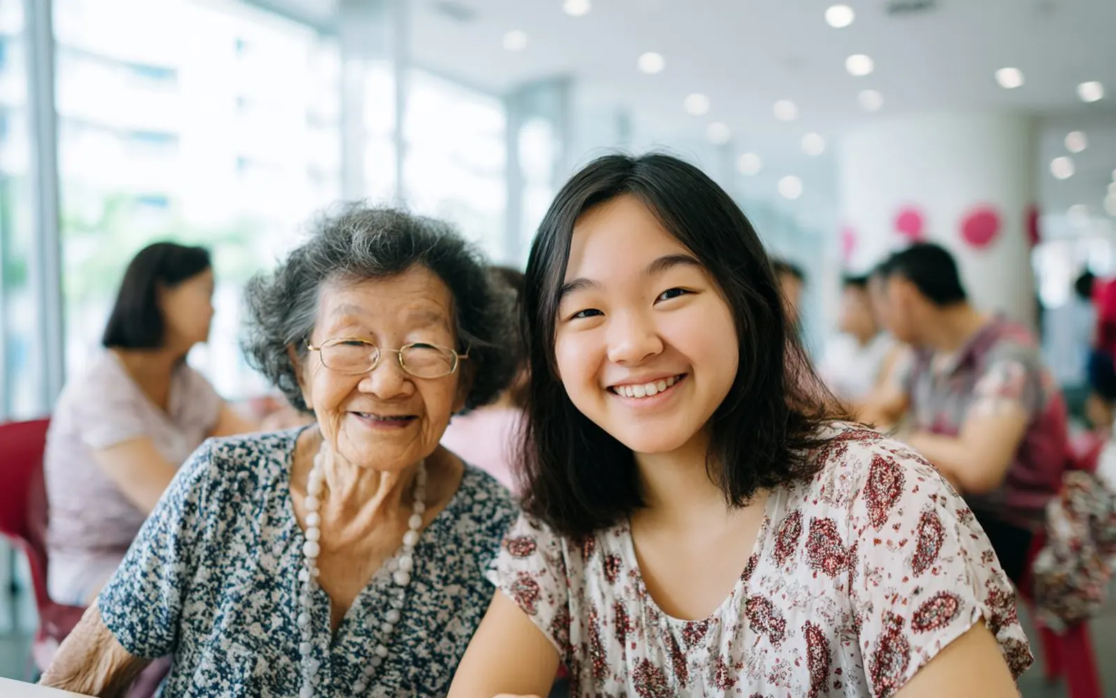 An older woman and a younger woman laughing together at a neighbourhood gathering